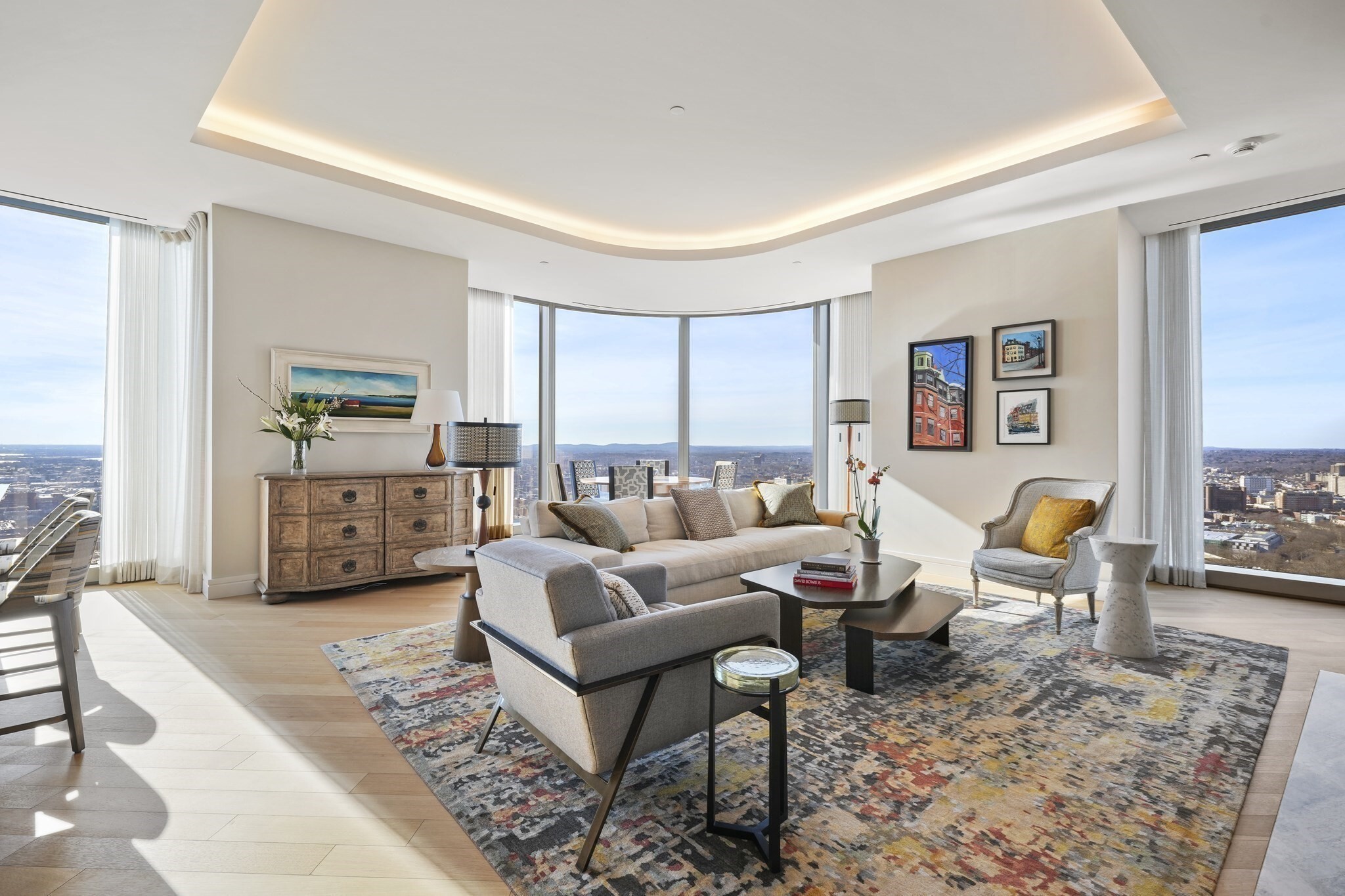 Exceptional 40th floor corner 3-bedroom home at One Dalton. Customized to perfection by Daher Interior Design. Begin your day with panoramic views spanning Boston Harbor to the Charles River & end your day with resplendent sunsets! The Gallery inspired entry hall & elegant rotunda invite you to the expansive entertaining space that features unique floor-to-ceiling curved glass windows, 11 ft cove ceilings, & gas fireplace with stone surround. SieMatic kitchen in Graphite Grey includes vented gas cooking & breakfast bar. Both stunning bedroom suites have en-suite bathrooms & generous custom closets. 3rd bedroom is versatile as it is outfitted with a custom queen Murphy bed that easily transforms into a full desk system. Other bespoke details include: custom lighting, millwork, electronic blinds, & white oak floors. Residents enjoy 24/7 service, world-class amenities, and multiple dining options including Zuma. Storage + valet parking complete this luxurious home!