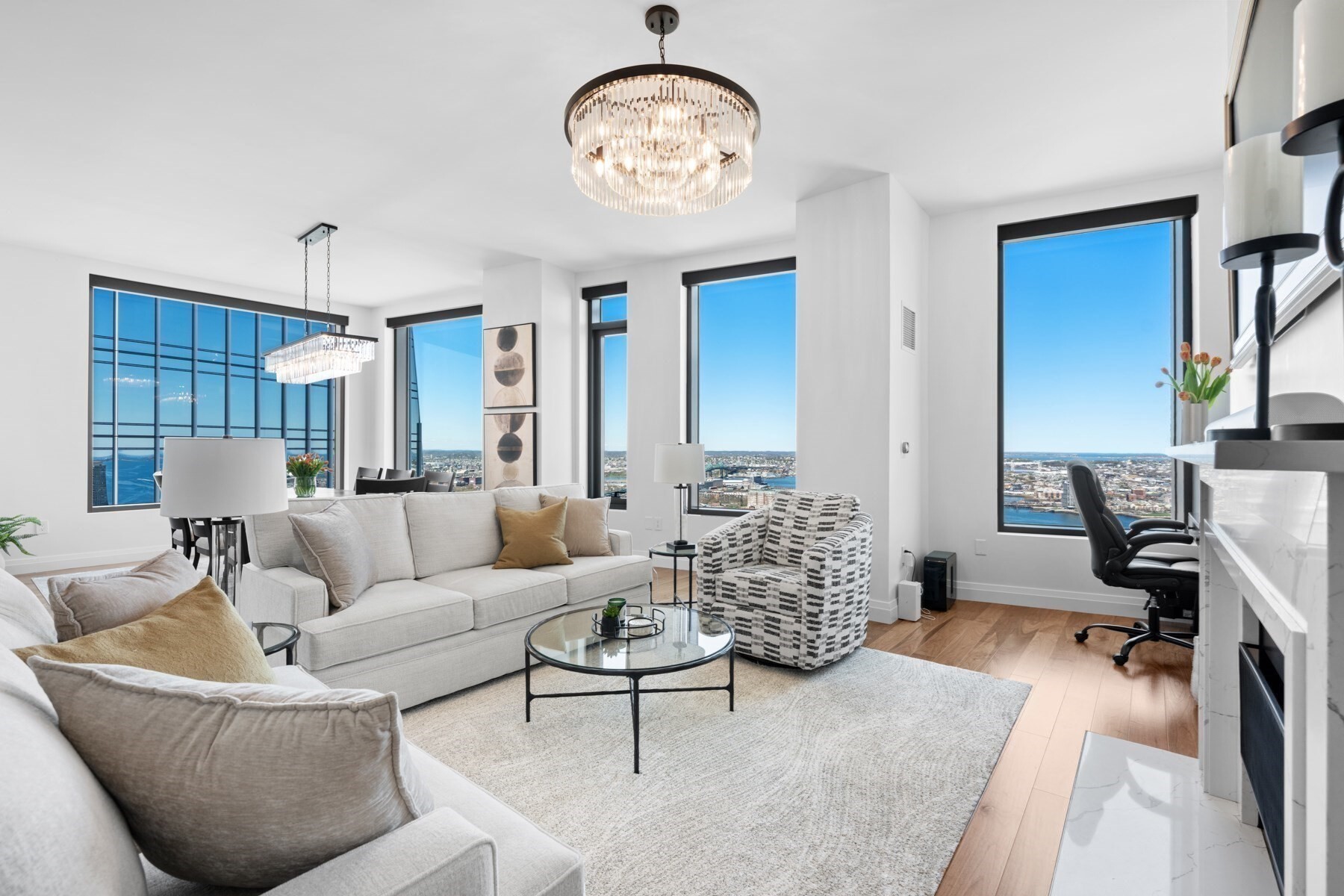 Perched on the 43rd floor of The Sudbury, this spectacular corner residence showcases panoramic views of Boston Harbor, the Charles River, Beacon Hill, the North End, and beyond to Cape Ann through dramatic floor-to-ceiling windows. An open-concept layout seamlessly connects the living, dining, and kitchen areas, creating an ideal setting for entertaining. The chef's kitchen features custom Scavolini cabinetry, quartz countertops, integrated Gaggenau appliances, vented gas cooking, and a wine refrigerator. A quartz-surround gas fireplace anchors the living room, while the serene primary suite offers sweeping sunset views and a spa-inspired bath. A spacious second bedroom, guest bath, two garage parking spaces, and world-class amenities—including an outdoor pool, fitness center, Sky Lounge, concierge, and rooftop garden—complete this exceptional offering in one of Boston's premier luxury residences.