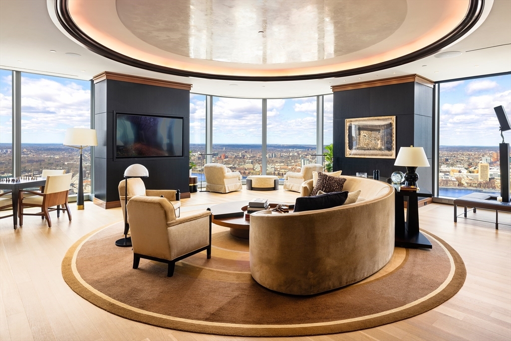 Experience unparalleled luxury at One Dalton, Unit 4901 — the only residence in the building designed by acclaimed interior architect Thierry Despont. Perched on the 49th floor, this customized 2-bedroom, 2.5-bath + office home spans over 3,600 square feet, showcasing extraordinary craftsmanship, millwork, and refined finishes — for the most discerning buyer. Breathtaking views of Boston, the Charles River, and Cambridge — with spectacular sunsets — frame the space throughout. The living, dining, and kitchen spaces flow effortlessly for entertaining and everyday living, complemented by 2 gas fireplaces and bar. The gracious primary suite offers a spa bath and custom dual dressing rooms. A second bedroom features an en-suite bath, and the office provides a work-from-home retreat. Two garage parking spaces complete the offering. Located within the Four Seasons Private Residences at One Dalton, residents enjoy 24-hour concierge, valet, fitness center, pool, spa, and dining in Back Bay.