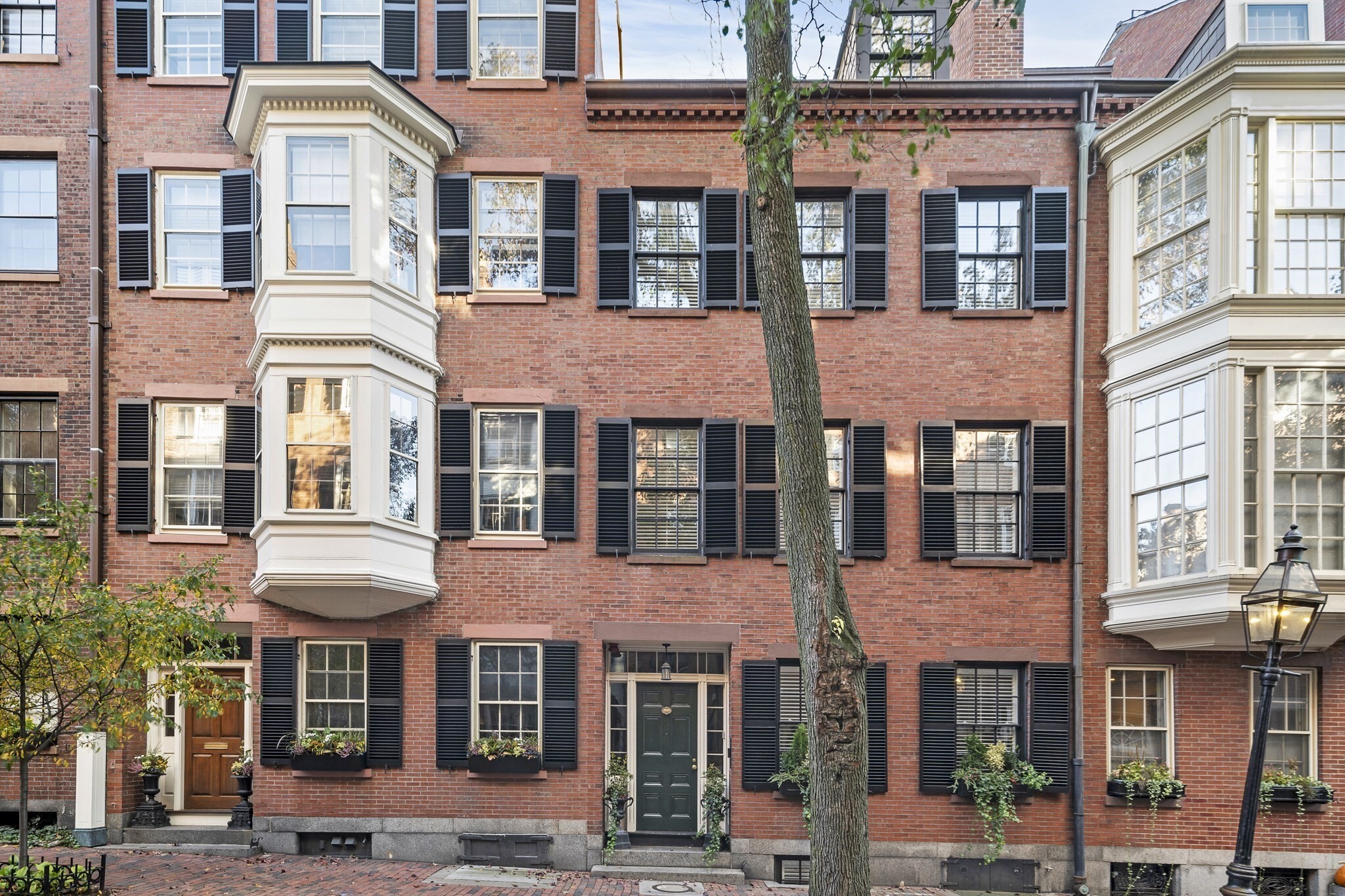 Welcome to 54 Pinckney Street! Tucked away on one of Beacon Hill’s most coveted blocks just steps from Louisburg Square, 54 Pinckney Street is a masterclass in refined city living. This meticulously renovated townhouse offers five sun-drenched levels of living space, steeped in a rich literary heritage as the former residence of Nathaniel Hawthorne. Every floor has been reimagined with an uncompromising eye for detail, creating a layout that flows effortlessly from one level to the next.At the heart of the home, the state-of-the-art kitchen is a chef’s dream, featuring sleek granite countertops and a premium appliance suite by Wolf, Sub-Zero, and Bosch. It opens directly onto a lush, private garden patio—a rare outdoor sanctuary that was recently featured on the prestigious Beacon Hill Hidden Garden Tour. This professionally planted oasis offers a level of horticultural beauty and privacy that is truly exceptional for the city.The second level serves as the home's centerpiece, boasting a grand formal living room with soaring ceilings and a handsome study/media room complete with a custom wet bar.The primary suite is a true retreat, with a large walk in closet and a breathtaking, spa-like bathroom anchored by a deep resin soaking tub and a glass enclosed shower room. The top floor contains 3 additional bedrooms and two full marble bathrooms featuring Water Works fixtures. Throughout the residence, five stately fireplaces, bespoke millwork, and rich hardwood floors add layers of warmth and character. Practicality is woven into the design with two laundry areas, all-new systems, and a versatile lower-level au pair suite. This private guest space includes a wine cellar, a new kitchen and its own separate entrance, providing independence and convenience for long-term visitors.A modern fire suppression sprinkler system and a security system is also in place.This is a masterful recreation of Old-World Boston, reimagined for a contemporary lifestyle with the highest caliber of craftsmanship and a storied past. Some photos are from a prior listing.