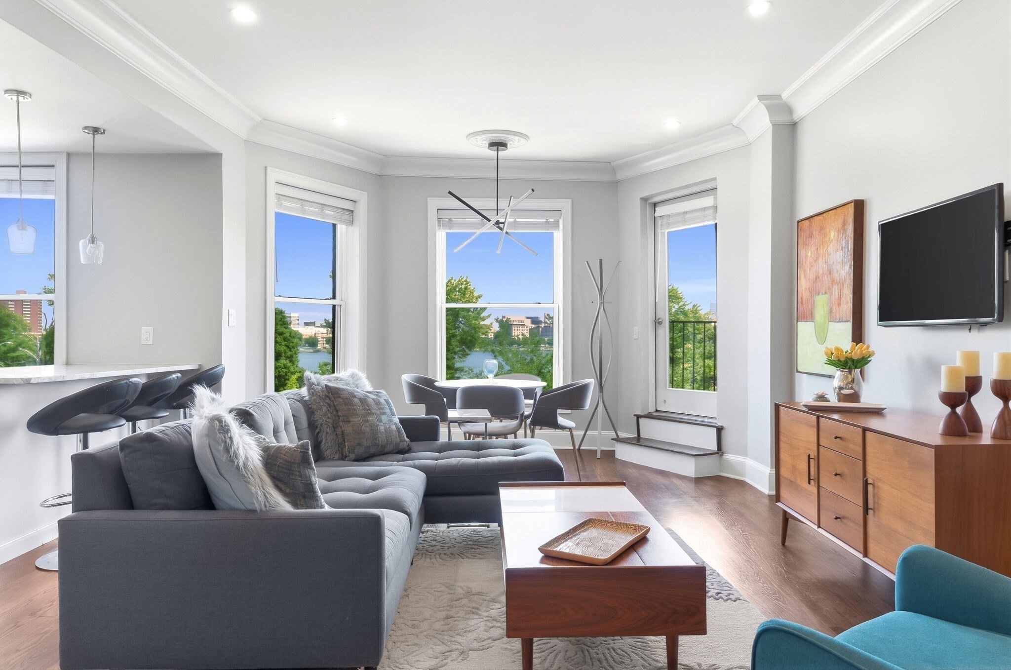 From the moment you step inside, you are greeted by expansive treetop and Charles River views through oversized windows that flood the entire space with natural light. This fully renovated condo features a seamless open-plan living and dining area that opens directly to your private deck overlooking the water. The gourmet cook’s kitchen is equipped with premium JennAir appliances, Quartzite countertops, extensive storage, and peninsula counter seating. Down the main hallway, you will find a spacious guest bedroom and a full guest bathroom with a tub and shower. The hallway leads to a stunning primary bedroom suite, complete with a cozy fireplace, two large closets, and a separate bay-window nook perfect for a home office or seating area. Its spa-like en-suite bathroom boasts a double vanity and a glass-enclosed walk-in shower. Modern conveniences abound with recessed lighting, an in-unit washer/dryer, elevator access, additional private storage, and a pet-friendly policy. Situated in an unbeatable location, you are just seconds from the T, major freeways, and the very best of Back Bay.