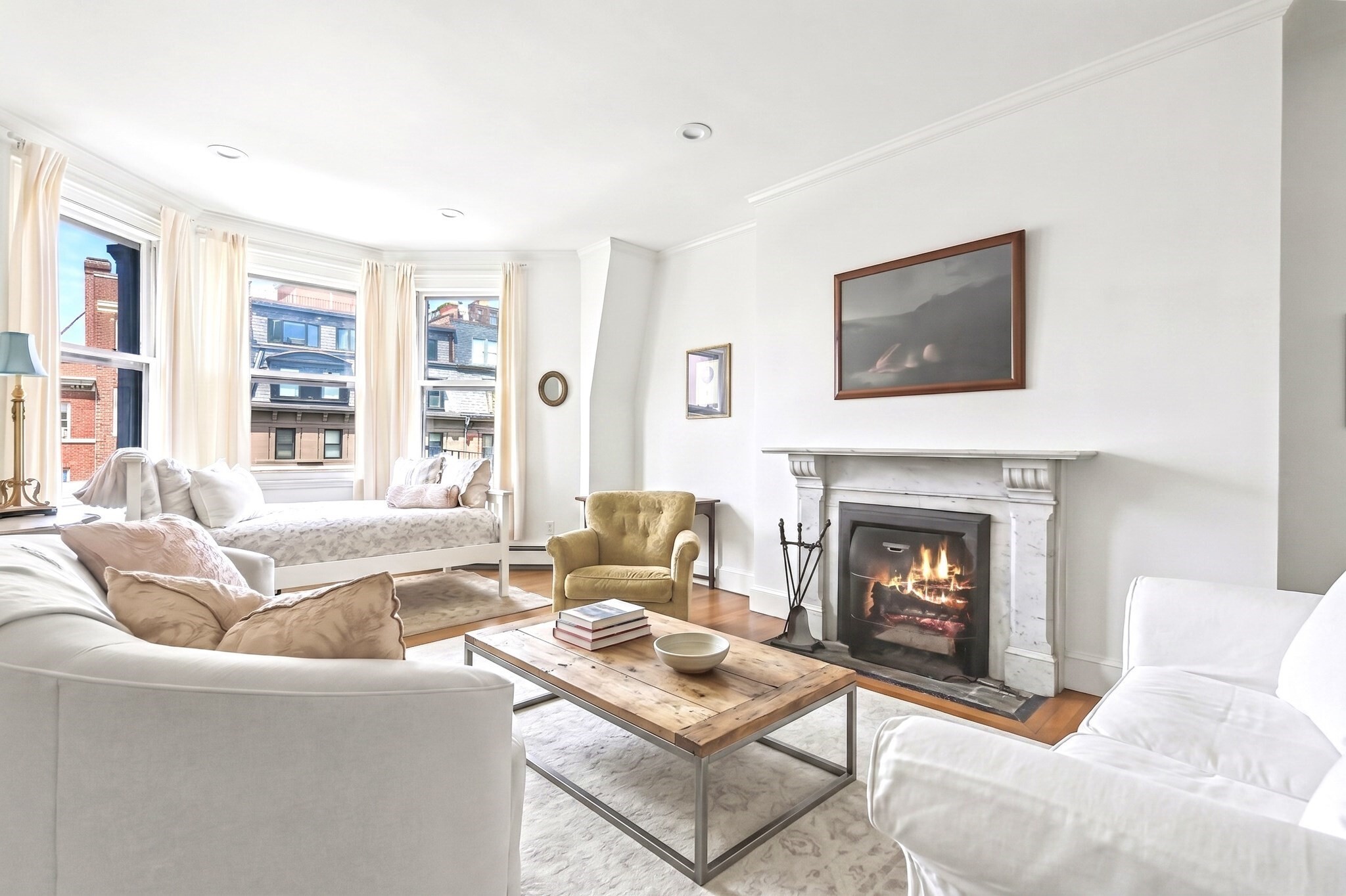 Perched atop a boutique building on Beacon Street, this sun-drenched Penthouse offers the best of Boston living. The renovated kitchen is beautifully appointed with marble countertops, stainless steel appliances, and a skylight that floods the space with natural light. The living room features gracious bay windows, crown moulding throughout, and a wood-burning fireplace with a marble mantle, creating a warm and inviting atmosphere. A dedicated dining area comfortably accommodates a table for six. French doors open to the bedroom, complete with two closets. The full bathroom features a tub/shower combo with navy stacked tile surround and brushed nickel fixtures. Enjoy sweeping views of the Boston skyline from the common roof deck. Discover a home as timeless as the neighborhood it belongs to!