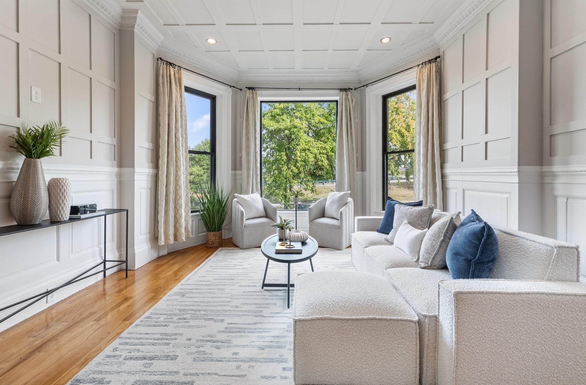 Timeless Back Bay architecture, Charles River views, and the rare convenience of direct-access parking come together in this distinctive duplex home on the highly regarded Bay State Road. Set within a classic brownstone, the residence showcases the craftsmanship and character that define one of Boston’s most iconic neighborhoods. The sun-filled main level is anchored by an elegant living and dining room, where oversized windows frame picturesque river views. Soaring 10-foot coffered ceilings, intricate crown moldings, raised-panel wainscoting, an original carved oak fireplace, built-in shelving, and rich hardwood floors create a warm and sophisticated setting for both everyday living and entertaining. The adjacent kitchen features Shaker-style cabinetry, stainless steel appliances, and its own river-facing window, while a conveniently placed powder room completes the main level. The private lower level features a spacious primary bedroom with bay windows and generous closet space. A second bedroom offers flexibility for guests, a home office, or additional living space. Direct access from this level to the building’s parking area adds an exceptional level of convenience, a coveted amenity in the heart of Back Bay. Residents also enjoy a common rooftop deck with panoramic views, offering a spectacular vantage point over the surrounding cityscape. Ideally situated along the Charles River Esplanade and moments from Newbury Street, Copley Square, the Public Garden, renowned restaurants, shopping, and public transportation, this home presents a rare opportunity to enjoy the beauty and character of historic Back Bay with the ease of modern city living.