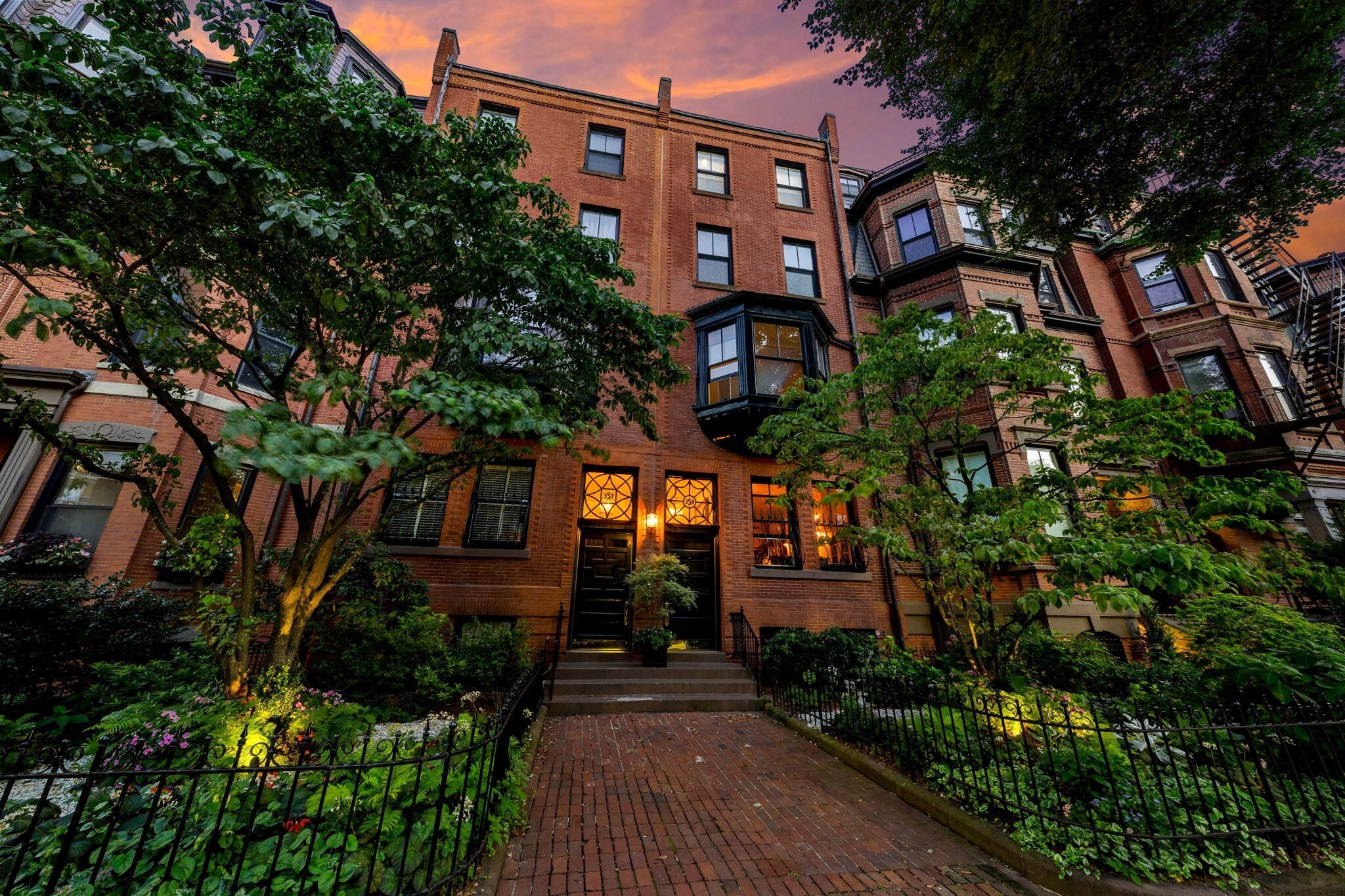 It took a quarter century to build, and most of it crossed the ocean by ship to get here. This is a 3-bedroom brownstone: 2,867 SF over three levels, three full bathrooms, and the option to add an extra half bath on the upper level. At the garden level, a private walled courtyard enclosed on all four sides. The rooftops above the wall are the only thing that tells you you're in Boston, not Europe. It is paved in French limestone hand-split in the 1700s, with a masonry fireplace, a grill, a real flue and a real damper built into the wall. If you want a wood fire outdoors in Back Bay, this is the only one. One off-street parking space opens straight onto the courtyard and the garden level. You park in Boston, walk down into the south of France and then directly into your private studio. Inside, the difference is something you feel before you can name it. A French farmhouse kitchen with a La Cornue range and limestone counters cut by hand. Quarter-sawn white oak underfoot, the most expensive way to cut a log. Hardware cast by P.E. Guerin, in business for over 150 years. THG Paris fittings and heated European towel racks in the bathrooms. Fireplaces throughout, two of them carved from onyx, one in a library with Grange bookcases and a rolling ladder. The owners bought a duplex in 1999 and two more floors in 2003, adding one of them to make the triplex. In between came a decade of stonemasons and blacksmiths, and orders placed in France, England and Italy. The same standard is held everywhere. Even the linen closet is floored in imported Italian ebony. A home like this cannot be built again. It can only be bought.