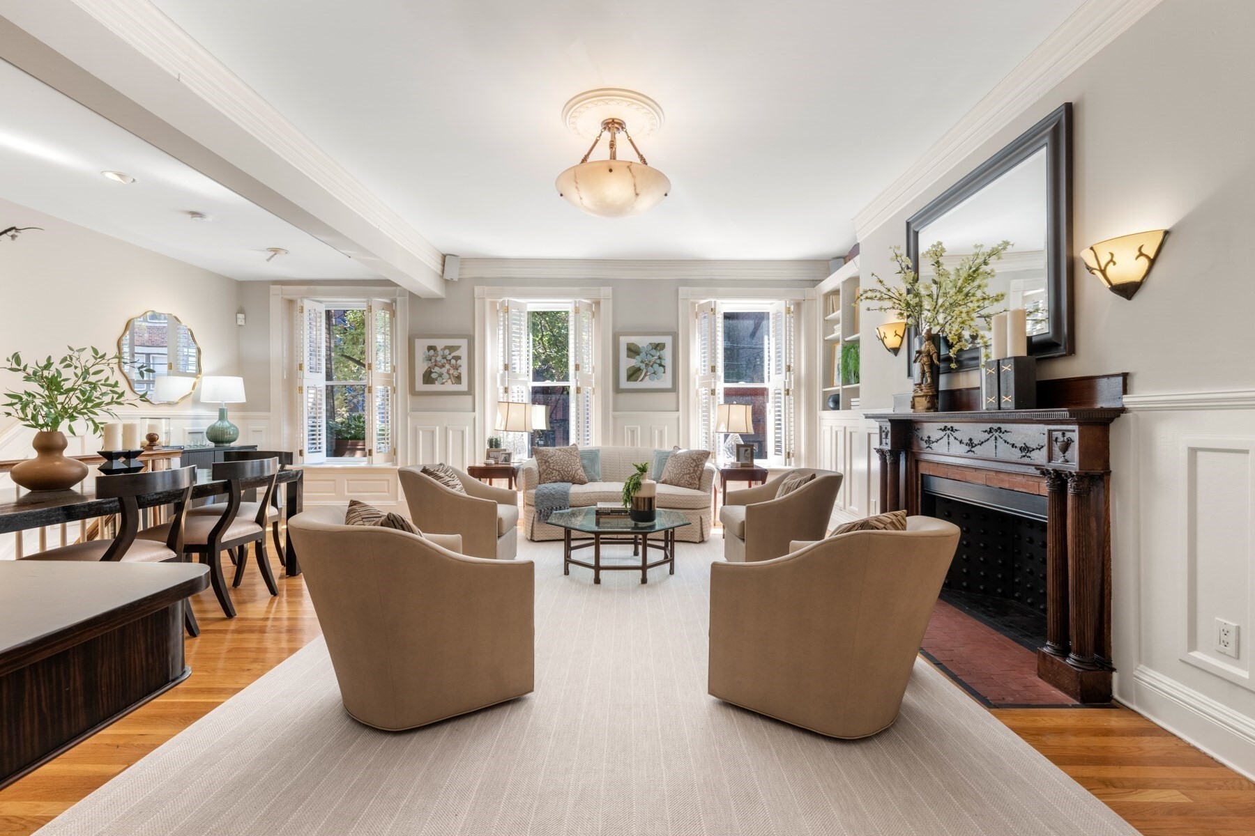 Designed by the renowned Boston architectural firm Peabody and Stearns and built in 1889, this elegant Marlborough Street parlor-and-garden-level duplex offers grandly proportioned rooms, a private walled garden, and two assigned and deeded parking spaces. A black-and-white marble-tiled foyer with a decorative marble fireplace welcomes you into the home and leads to a striking front room overlooking Marlborough Street. Anchored by an impressive fireplace with a beautiful Siena marble surround and hearth and an Italian crystal chandelier, this versatile space is ideal for formal dining, a second living room, library, or home office.The exceptionally wide living room features three large windows with Back Bay Shutters, custom built-in bookcases, and a third fireplace. Its generous scale accommodates both comfortable daily living and an informal dining area. The adjacent kitchen includes granite countertops, a tiled backsplash, and high-end appliances.The primary suite overlooks the private garden and features a five-piece marble en-suite bath. An internal study with French Doors, built-in bookcases, and a Murphy bed provides flexible space and is situated beside the guest suite. The guest bedroom includes a tiled en-suite bath with shower, extensive built-in cabinetry, and an additional Murphy bed.A bright, heated sunroom overlooks the garden and can be enjoyed year-round. The colorful, walled garden provides a private outdoor setting for dining and entertaining, with direct access to two assigned and deeded parking spaces.