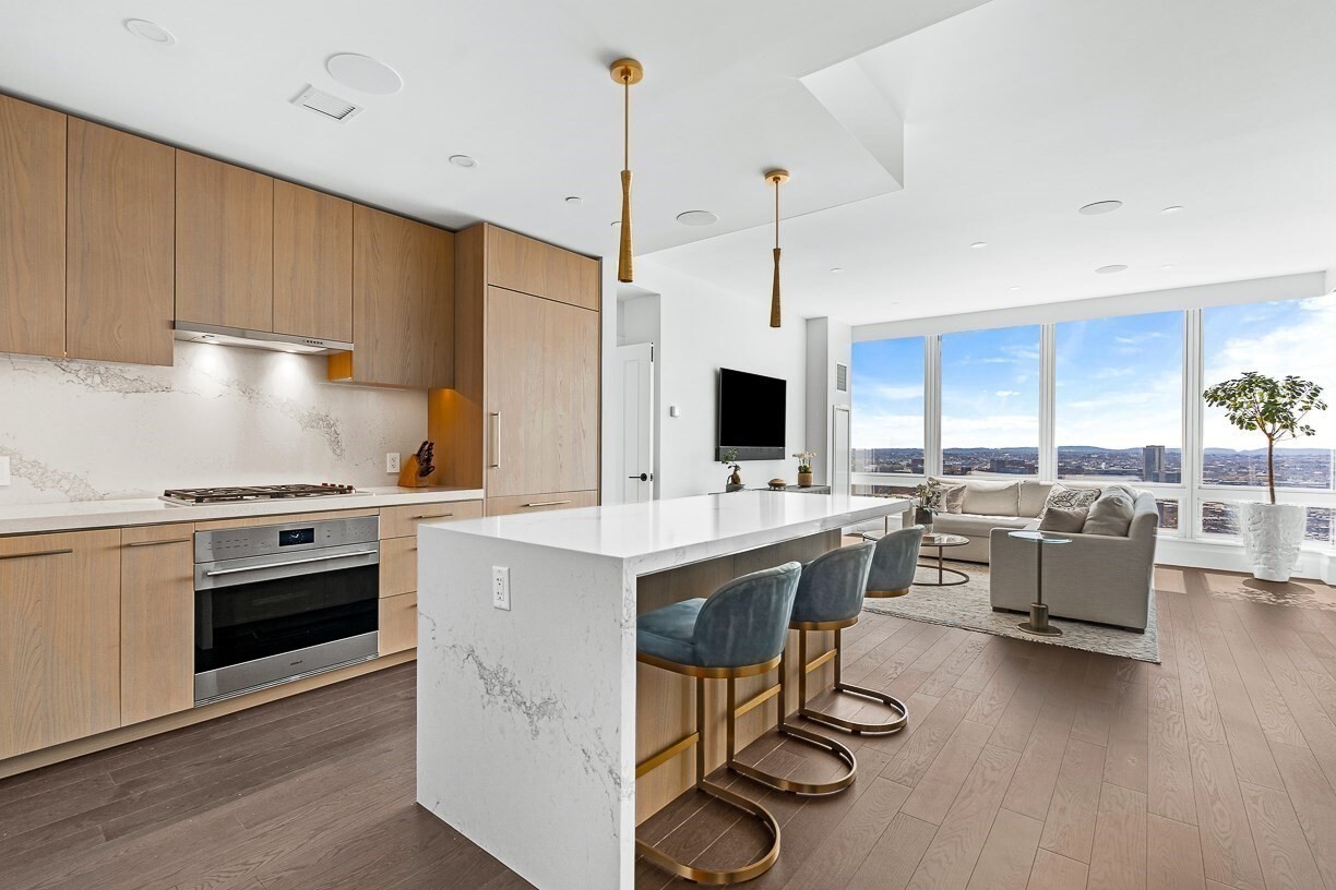 Residence 23J - Raffles Boston offers a rare opportunity to acquire a coveted corner floor plan, available for the first time since the sellout of the upper residences. This 1,752-square-foot, two-bedroom plus den, two-and-a-half-bath home pairs bespoke design with the service and lifestyle of Raffles. Southeast exposures fill the 23rd-floor residence with natural light and frame sweeping views over Back Bay, the South End, Boston Harbor, and the city skyline. A private terrace offers a tranquil setting above the city. Thoughtfully enhanced beyond developer specifications, the home features integrated Lutron lighting and automation, custom blinds, layered lighting, bespoke wall treatments, and tailored millwork. The spacious den has been transformed into an elegant office with a full-wall built-in and retractable desk ready to receive overnight guests. The chef’s kitchen features Sub-Zero and Wolf appliances, quartz surfaces, and custom detailing. The primary suite offers three custom closets and a spa-inspired bath with a soaking tub. The secondary bedroom includes custom closet systems and designer finishes. Specialized acoustic glass panels and sound-mitigating window upgrades bring an exceptional sense of calm to this city residence. Two parking spaces with 24-hour valet service—complete the offering. Residents enjoy a 24-hour concierge and doorman, Raffles Butler service, an indoor lap pool and spa, fitness center, outdoor terraces, wine and entertaining spaces, a golf simulator, library lounge, pet amenities, and dining destinations including Long Bar & Terrace, La Padrona, and The Blind Duck. Residence 23J is a turnkey home defined by thoughtful design, privacy, and the distinctive Raffles lifestyle.