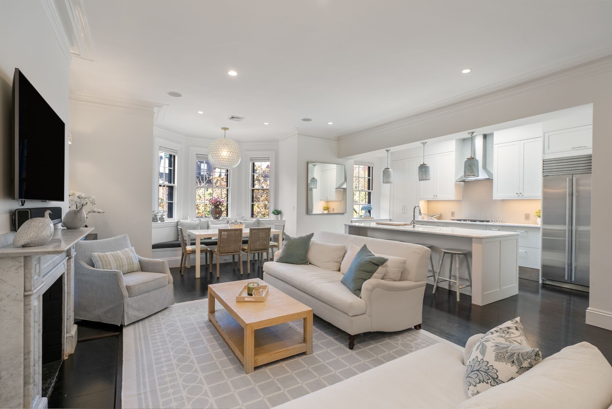 Set on one of Marlborough Street’s most coveted blocks, this beautifully renovated top-floor duplex combines classic Back Bay character with an exceptional indoor-outdoor layout rarely found in the neighborhood.  The main level offers an open, gracious flow among the living, dining and kitchen areas, framed by a front-facing bay, marble fireplace and custom built-ins. Two bedrooms are privately positioned at the rear of the residence.  The primary suite features skyline views, a second marble fireplace, a walk-through closet and a renovated en suite bath.  A well-proportioned second bedroom and an additional renovated full bath complete this level.  Upstairs, a window-lined lounge creates a distinct second living space, complete with wet bar and powder room.  Equally well-suited to entertaining, working and unwinding, the lounge opens directly onto an expansive private wraparound roof deck, thoughtfully arranged into distinct areas for dining, lounging and gathering.  This seamless, same-level indoor-outdoor connection - exceptional in both scale and versatility - is a defining feature of the residence and a true rarity in Back Bay.  Additional features include in-unit laundry, central HVAC, integrated lighting and audio, and dedicated storage.  Offering an uncommon combination of privacy, architectural character and expansive outdoor living, this distinctive residence presents a compelling opportunity in one of Boston’s most enduringly desirable neighborhoods.